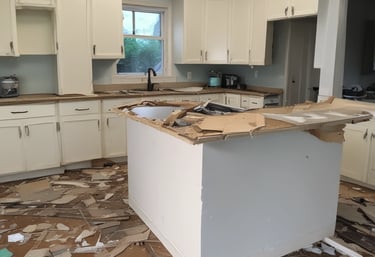 Close-up of a team member carefully removing kitchen cabinets during demolition.