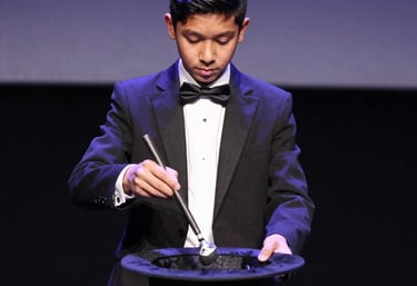 A lively audience clapping and cheering during a talent competition night.