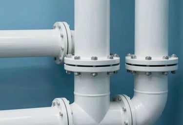 Close-up of clean, professionally maintained sewage pipes in a technical room of a German residential building, light blue and white color scheme.