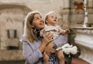 Krikštynų fotografija - močiutė ant rankų laiko savo anūką
