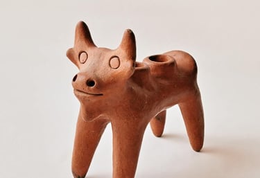 Figurilla artesanal de vaca elaborada en barro terracota, con acabado rústico en tono café y diseño.