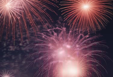 A vibrant fireworks display lighting up the night sky over a festive crowd celebrating the New Year.