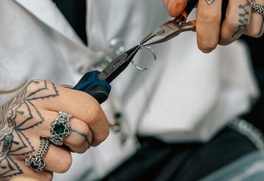 Un joyero tatuado utiliza pinzas especializadas para joyería artesanal