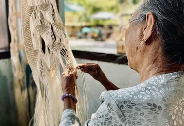 mujer mayor tejiendo adorno de macramé en un taller al aire libre