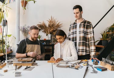 tres personas elaborando joyería artesanal con instrumentos especializados
