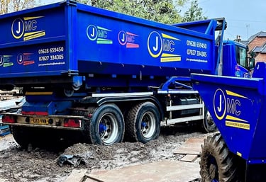 Blue JMC groundworks and demolition tipper truck and site dumper on a muddy construction site.