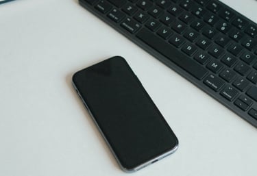 Top-down view of a clean, organized office desk with a smartphone, a high-end keyboard, and a notebook, professional and efficient aesthetic with muted teal tones.