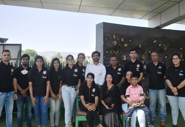 a group of people standing for click picture as a team