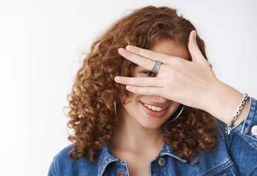 a woman with curly hair and a ring on her finger
