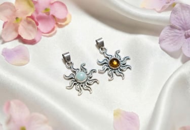 a pair of earrings with a flower on a white cloth