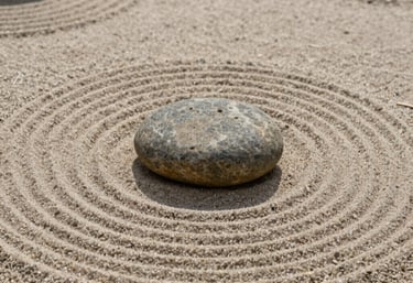 Minimalist Japanese garden with a single smooth stone resting on raked sand, representing clarity and focus in design.