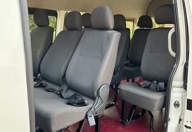 Interior of a white passenger commuter van with comfortable recliner seats
