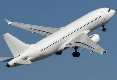 A cheerful traveler booking flights online with a laptop and coffee in a cozy home setting.