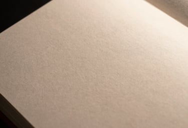 A focused shot of high-quality paper texture and minimalist layout design in a professional portfolio, dark environment with warm highlights.