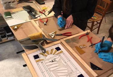 Découpe du verre lors d'un stage d'initiation au vitrail au plomb, atelier Paris 17e