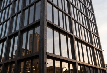 The sleek exterior facade of a renovated Brazilian commercial building featuring glass and charcoal-colored steel, during the golden hour, reflecting a modern aesthetic.