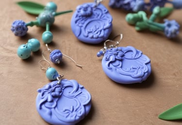 Close-up of delicate polymer clay flowers in periwinkle and creme colors.