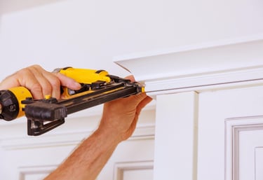 handyman repairing interior trim with a power drill in an Auckland home