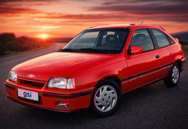 Kadett GSI vermelho zero km em fundo de pôr do sol com placa dianteira escrita GSI