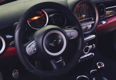 a car dashboard with a steering wheel and dashboard controls