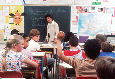 Teacher and students working in a classroom environment.