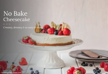 No bake cheesecake topped with fresh strawberries and blueberries on a white cake stand.