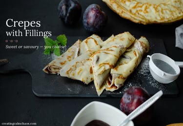 Rolled crepes with fillings served on a dark board with fresh plums and powdered sugar.