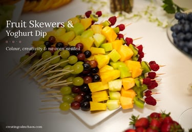 Fresh fruit skewers with pineapple, melon, grapes, and berries on a white platter for a healthy party snack.