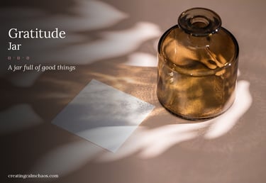 A brown glass gratitude jar with a white paper note and aesthetic shadows on a beige surface.