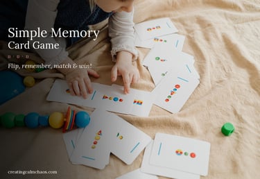 A young child plays a simple memory card game with colorful geometric patterns on a soft blanket.