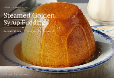 A classic steamed golden syrup sponge pudding drizzled with syrup on a decorative plate.