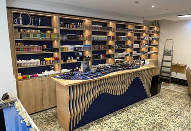 Modern vape shop interior with shelves of e-liquids and a display counter of vaping devices.