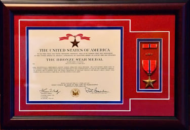 Framed Bronze Star Medal certificate and military award for service in Iraq with red and blue matting.