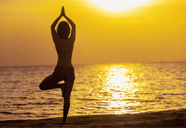 a person doing yoga on the beach