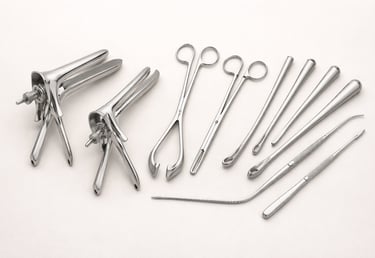 Gynecology instruments such as speculums, forceps, and probes on a white background.