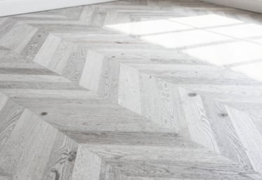 Macro close-up of a master craftsman hand-restoring historic oak parquet flooring in a Parisian apartment, soft natural side lighting, dust particles visible in sunlight, extreme precision focus
