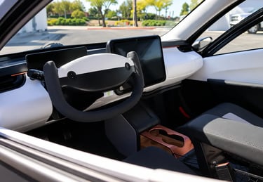 Interior do Aptera Solar EV com volante futurista, telas digitais e cabine minimalista