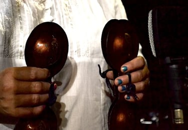a woman in a white shirt and blue nails with a pair of scissors
