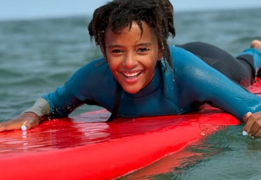 Girl laying on a surfboard at the Best Surf School in New Hampshire E Street Surf School 