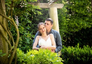 Portrait d'un couple s'étreignant devant une structure en bois avec fleurs