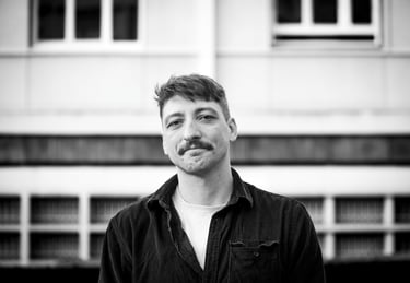 Portrait noir et blanc d'un homme avec une moustache dans un décor urbain