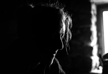 Portrait noir et blanc d'une personne devant une fenêtre