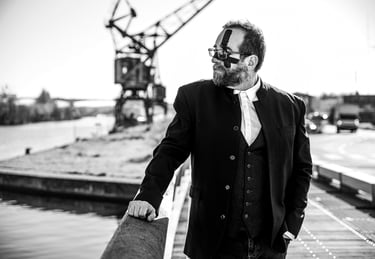 Photographie artistique N&B d'un homme en costume-cravate se tenant sur un quai