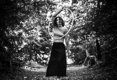 Photographie artistique N&B d'une femme vêtue d'une jupe faisant du cerceau