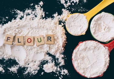 flour and measuring cups on a kitchen counter