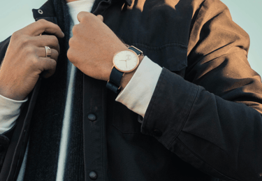 a man in a black jacket and a watch