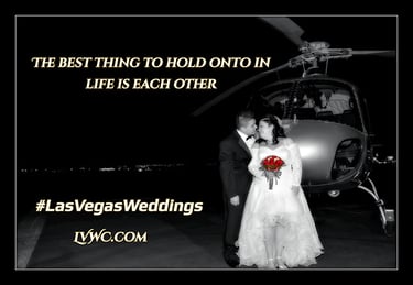 a bride and groom standing in front of a helicopter