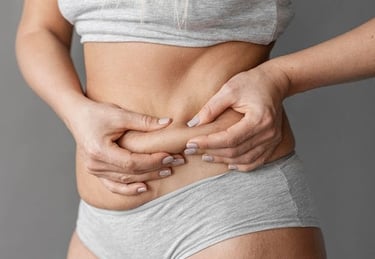 Mujer tomando grasa localizada en el abdomen