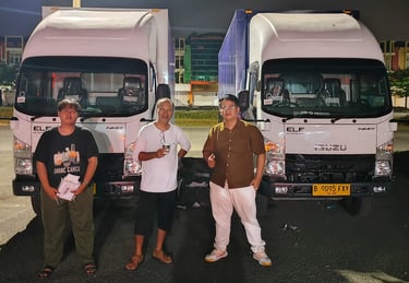 three men standing next to each other in front of a truck