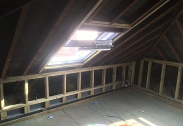 Loft conversion interior framing with roof window installation in Brighton property.